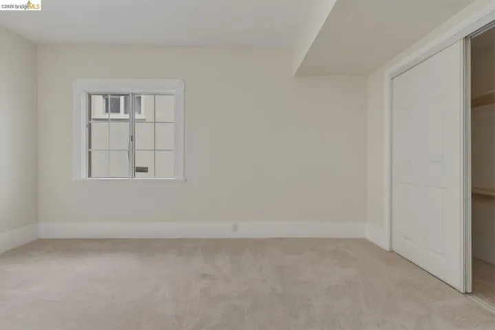 Neutral-toned carpeting and walls complement a multi-pane window with white trim