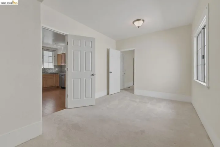 Spacious room with light-toned wall finishes and soft carpeting