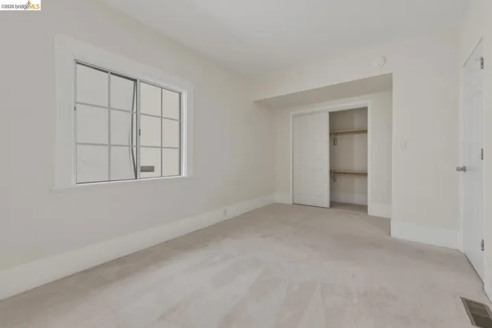 Neutral-toned carpeting throughout this room with a window featuring grid panes