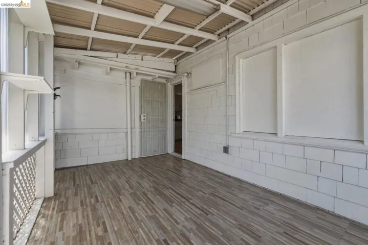 Covered porch featuring wood-finish flooring and a white corrugated ceiling
