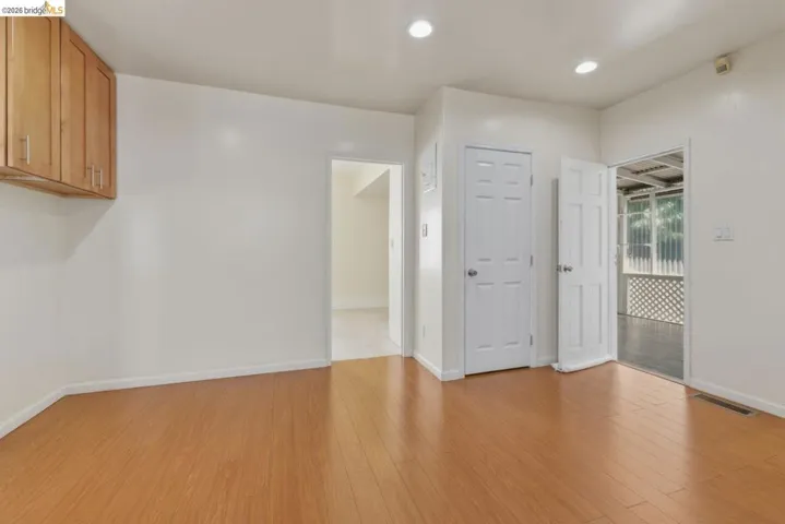 Bright room featuring wood-finish flooring and recessed lighting