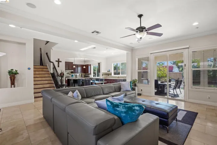 Spacious living area featuring tile flooring, a ceiling fan, and recessed lighting