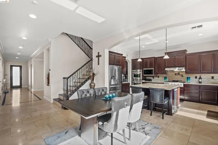 Gourmet kitchen with dark wood cabinetry, stainless steel appliances, and a central island with bar seating