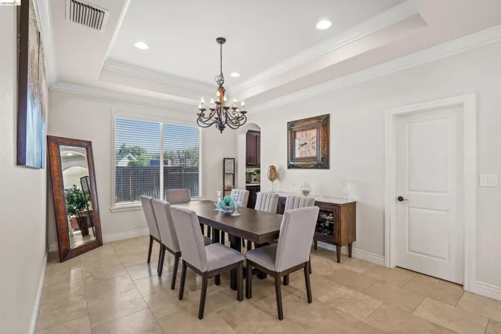 Dining area featuring a coffered ceiling with recessed lighting and a classic chandelier
