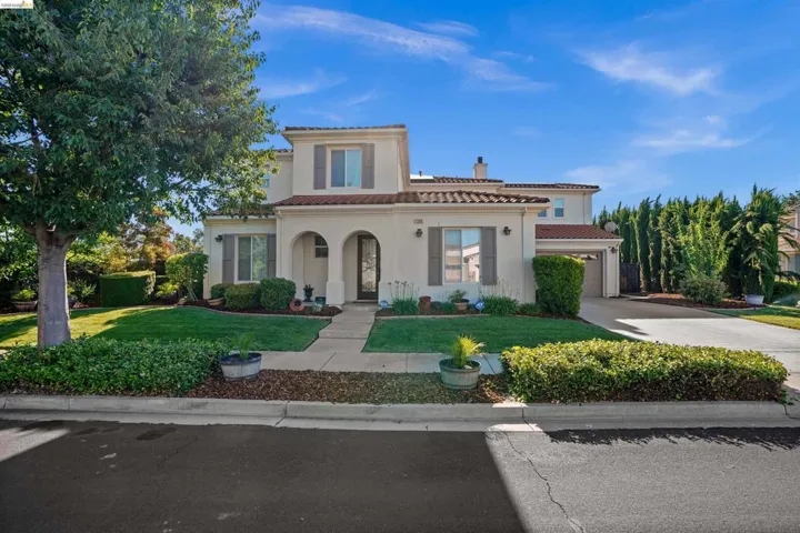 Stucco exterior residence featuring a tile roof and arched entry
