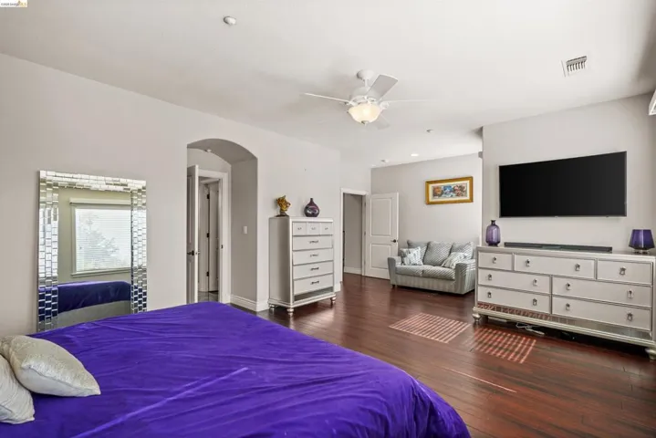Spacious bedroom featuring wood-finish flooring and light gray walls