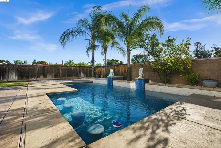 Outdoor swimming pool featuring integrated submerged bar stools