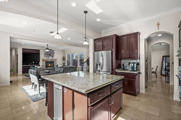 Kitchen featuring a central island with a light-toned countertop, dark wood-finish cabinetry, and stainless steel appliances