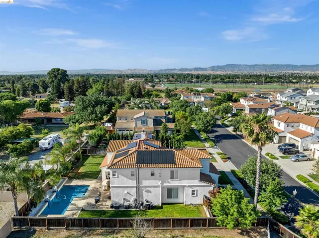Aerial perspective showcasing a tiled roof, solar panels, and a private swimming pool