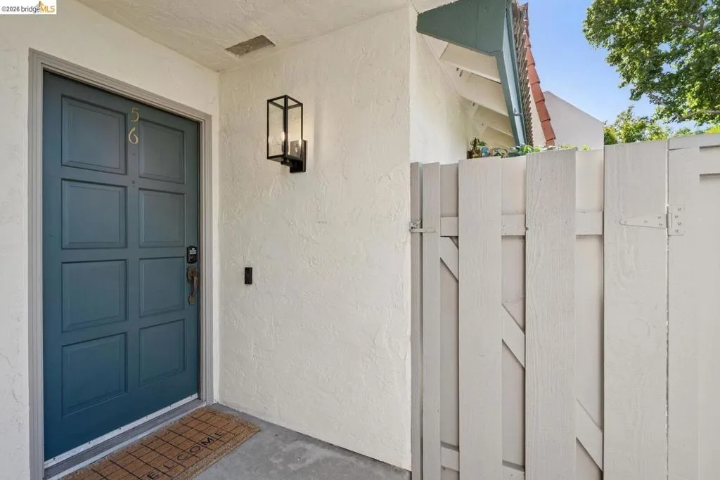 Paneled entry door with textured stucco exterior
