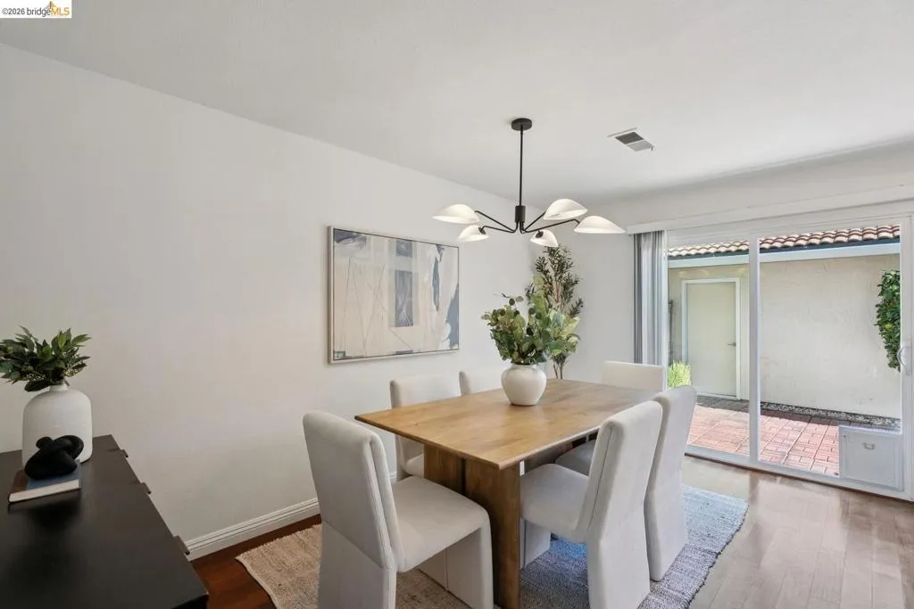 Dining area featuring wood-finish flooring and a contemporary chandelier