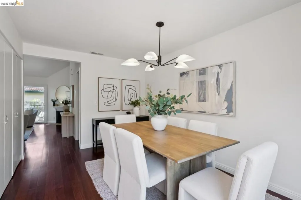Dining area featuring wood-finish flooring, a contemporary ceiling light fixture, and white baseboards