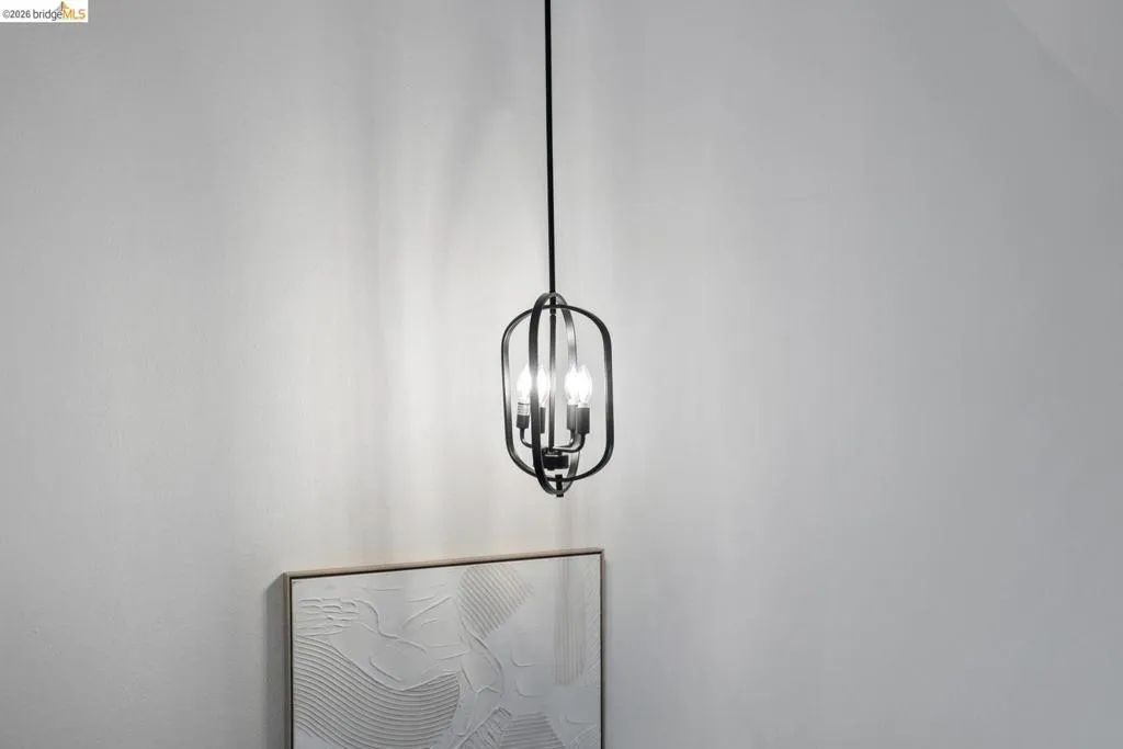 Black metal open-cage pendant light fixture with exposed bulbs