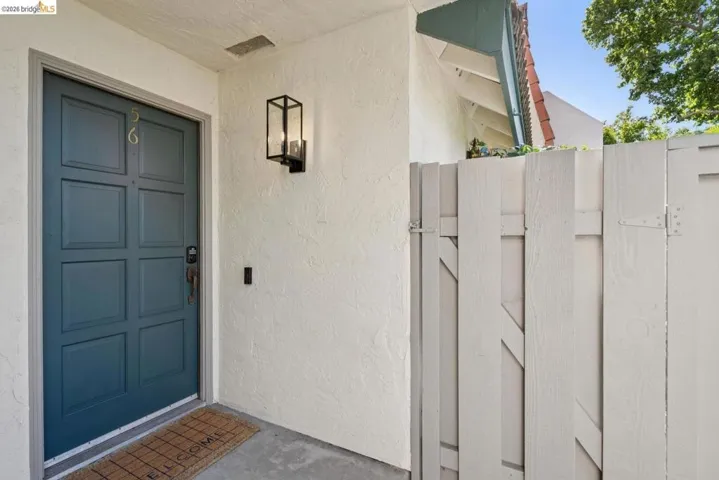 Paneled entry door with textured stucco exterior