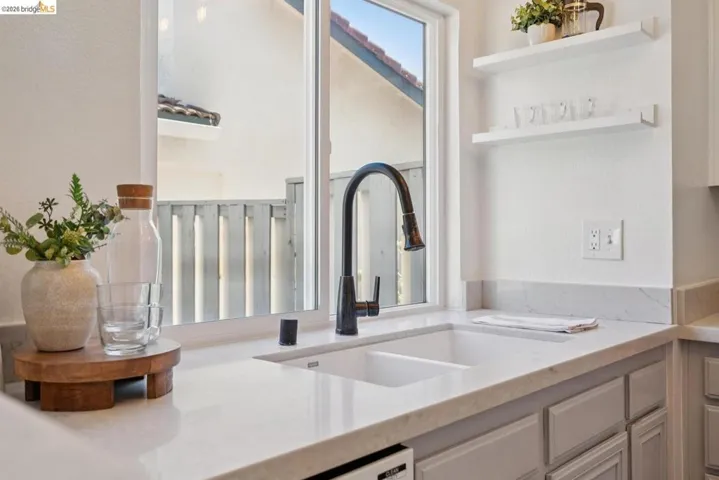 Kitchen sink with a high-arc faucet, set within a light-toned countertop