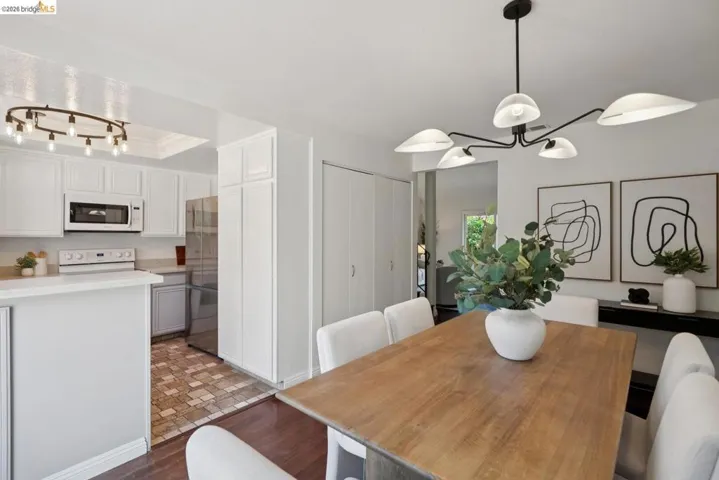 Dining area featuring a contemporary chandelier, hardwood flooring, and neutral wall tones