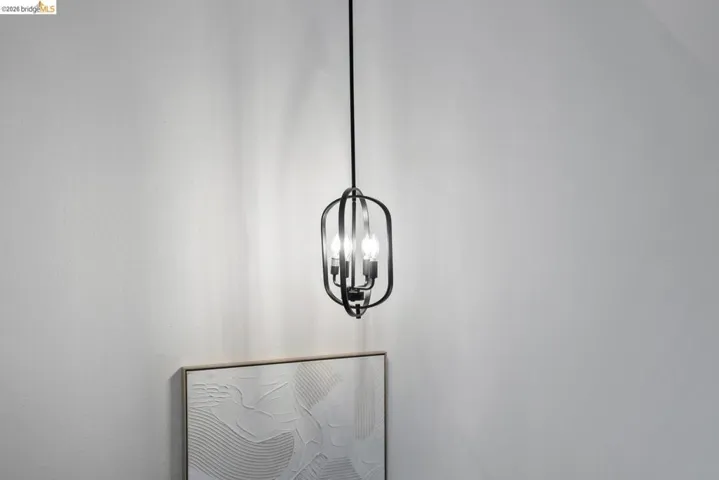 Black metal open-cage pendant light fixture with exposed bulbs