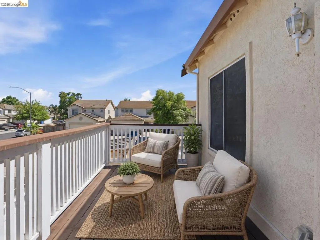 Outdoor deck featuring wood-finish flooring, white railing, and a textured stucco exterior wall