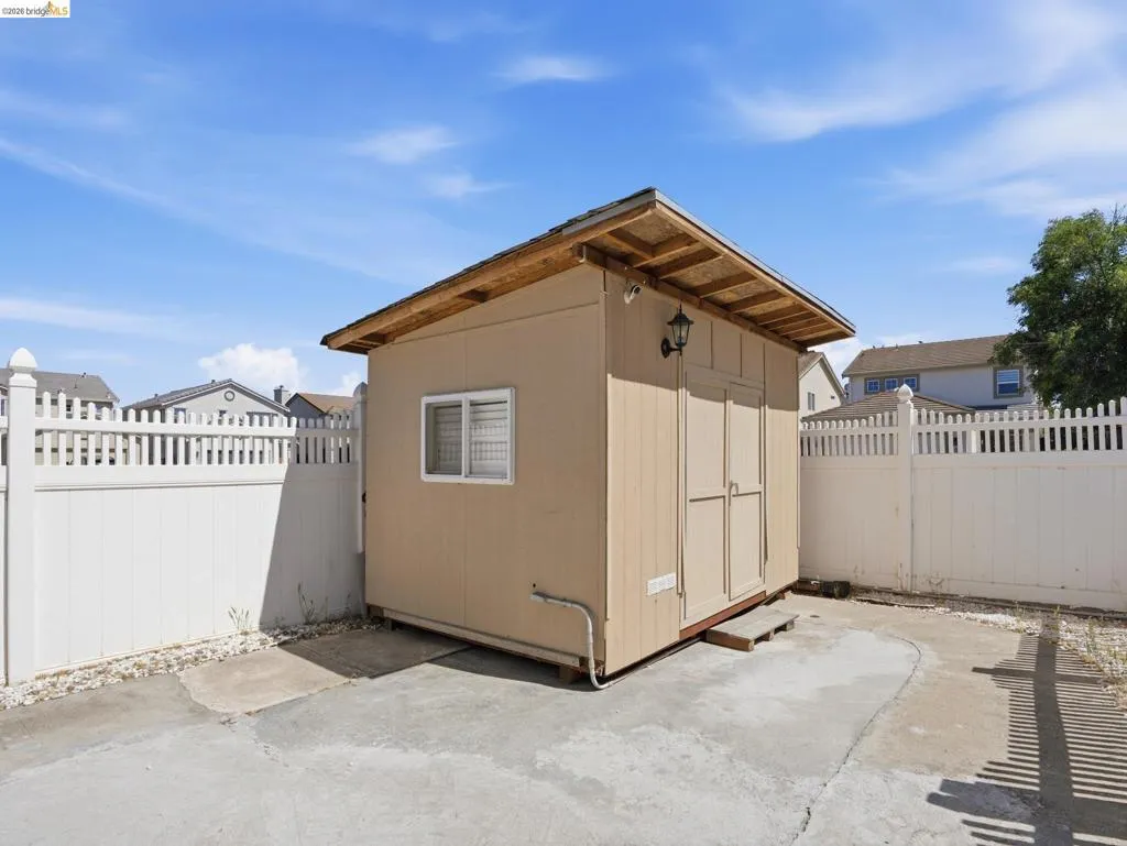 Freestanding utility shed featuring a window, double doors, and an exterior light fixture