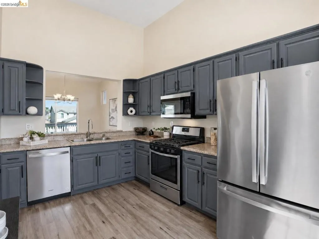 Kitchen featuring shaker-style cabinetry, light-toned countertops, and wood-finish flooring