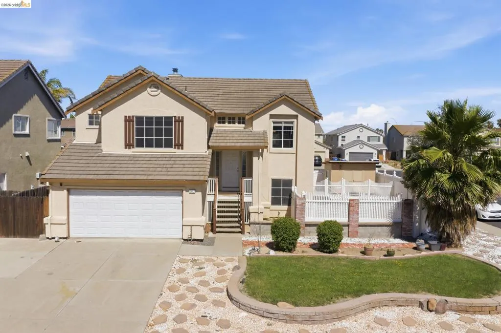Two-story stucco residence with a tile roof and attached garage