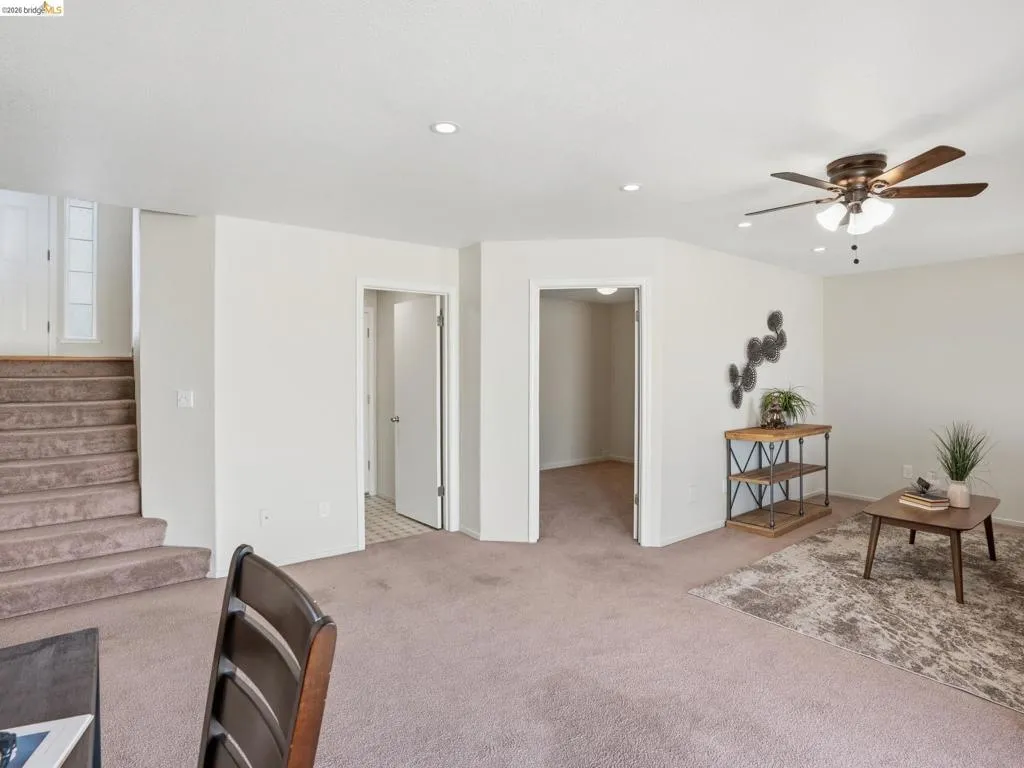 Carpeted living area featuring recessed lighting, a ceiling fan, and two interior doorways