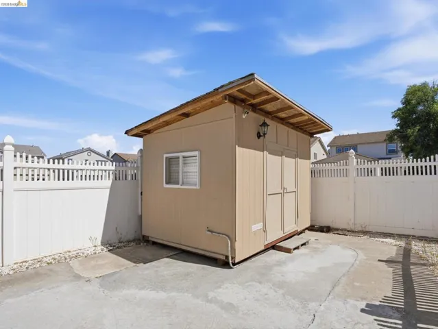 Freestanding utility shed featuring a window, double doors, and an exterior light fixture