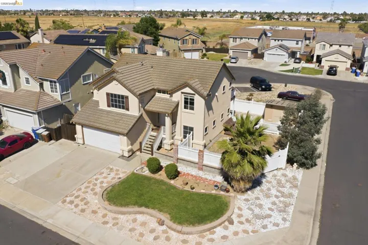 Two-story stucco residence with a tiled roof and an attached two-car garage