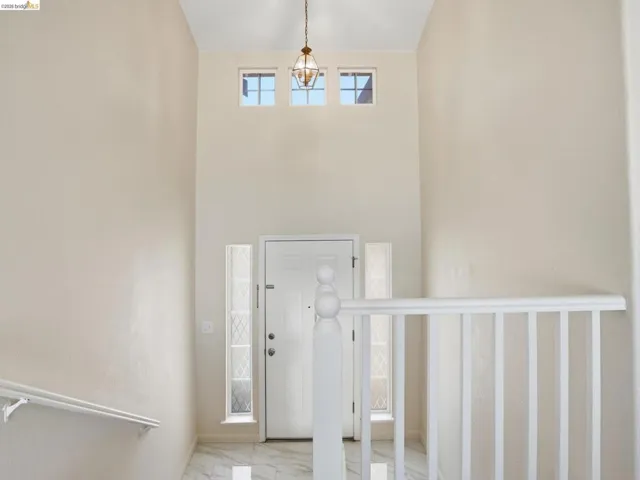 Entryway featuring a high ceiling, a decorative pendant light fixture, and three transom windows