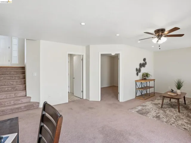 Carpeted living area featuring recessed lighting, a ceiling fan, and two interior doorways