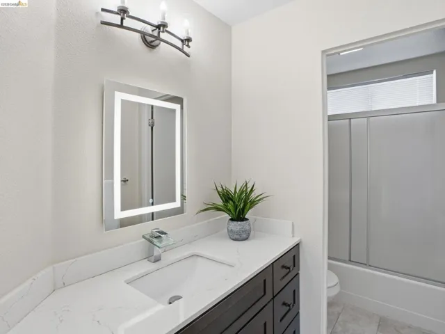 Bathroom vanity featuring a rectangular undermount sink, a white quartz countertop, and a dark wood-finish cabinet