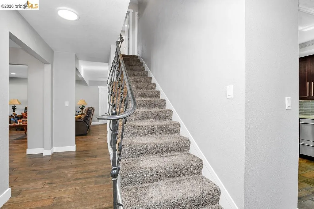 Carpeted staircase with an ornate wrought iron handrail