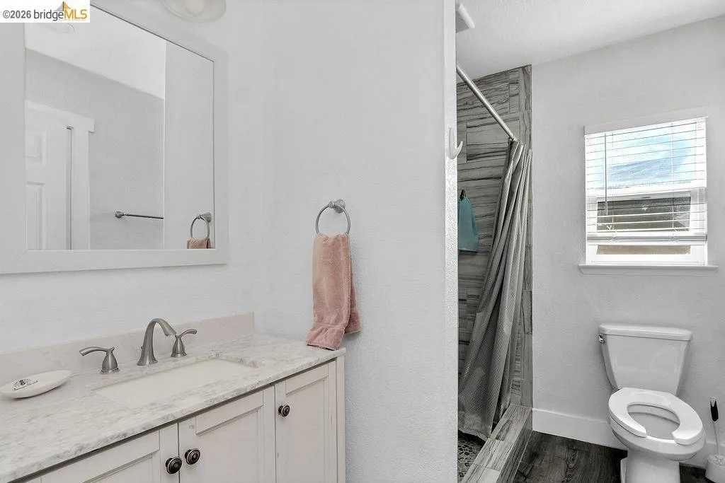 Bathroom featuring a single vanity with a light-toned countertop, undermount sink, and brushed nickel faucet