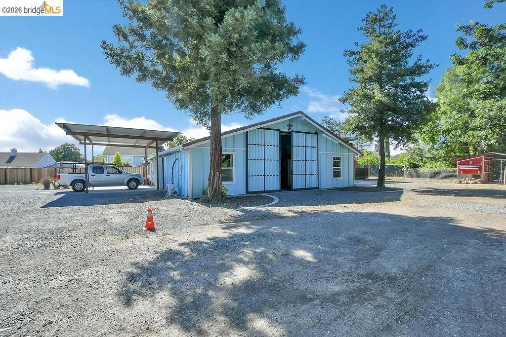 Light blue barn structure featuring large sliding doors and a gabled roof