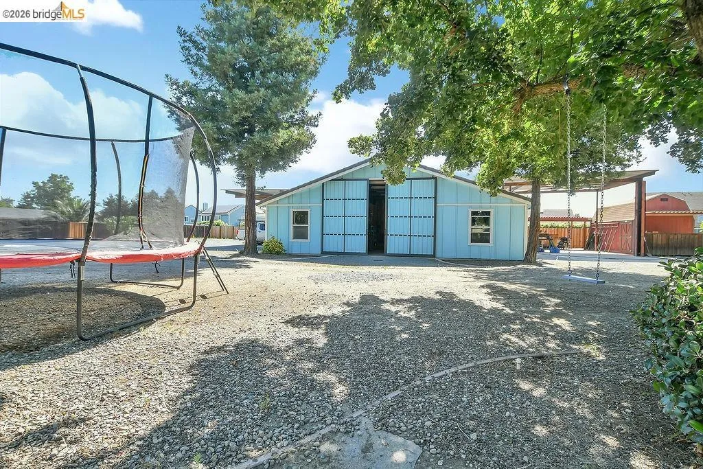 Light blue barn-style structure featuring large sliding doors and a side window