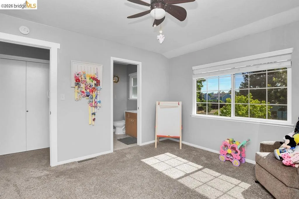 Room featuring a large window, soft gray wall paint, and gray carpet flooring
