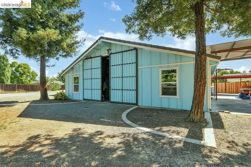 Light blue siding structure with a dark shingle roof and white trim