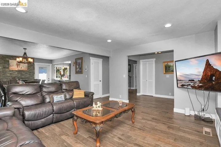Living area featuring wood-finish flooring, recessed lighting, and a neutral wall palette
