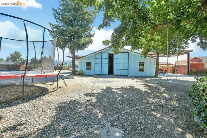 Light blue barn-style structure featuring large sliding doors and a side window