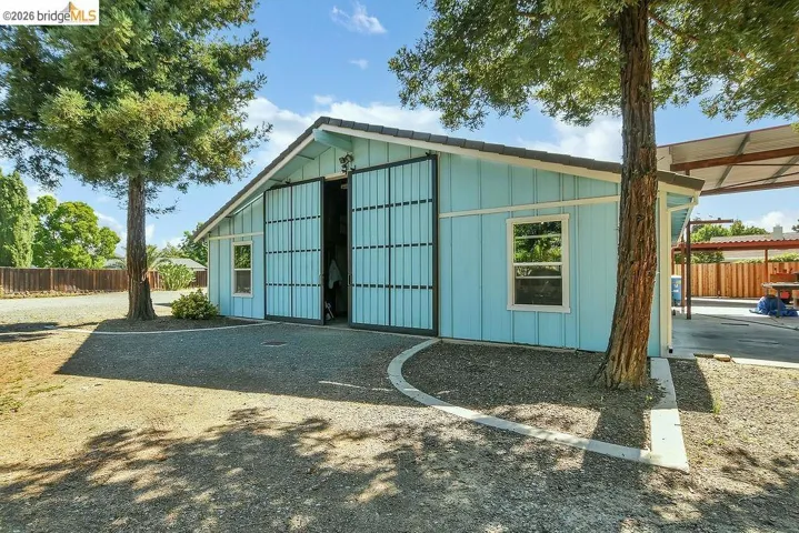 Light blue siding structure with a dark shingle roof and white trim