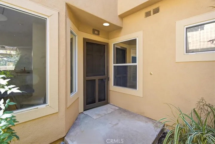 Covered entry courtyard with natural light and welcoming approach.