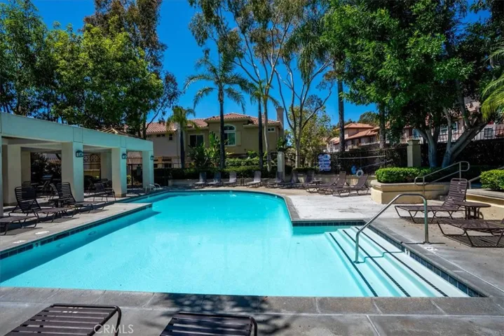 Resort-style pool area surrounded by mature landscaping and lounge space.