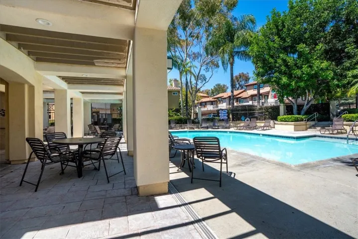 Covered patio overlooking pool, ideal for outdoor dining and entertaining.