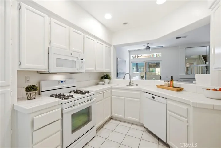 Kitchen showcasing white cabinetry, updated appliances, and clean design.