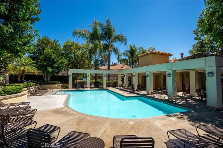 Covered outdoor lounge area adjacent to pool for entertaining guests.