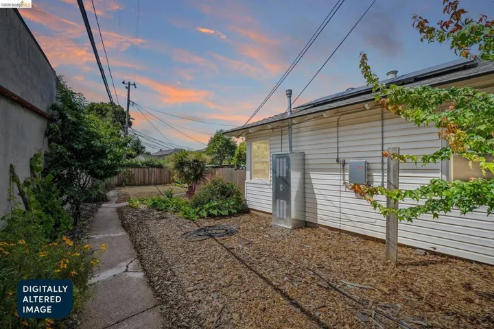 Rear exterior with horizontal siding and a paved pathway