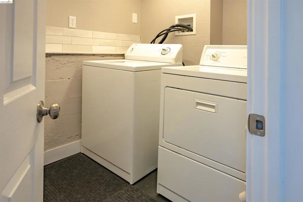Dedicated laundry area featuring a white washer and dryer set, subway tile backsplash, and a neutral wall color