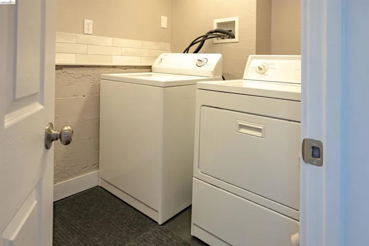 Dedicated laundry area featuring a white washer and dryer set, subway tile backsplash, and a neutral wall color