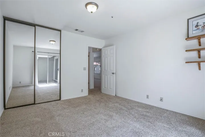 Guest bedroom with freshly cleaned carpets, lots of natural light and access to yard