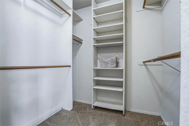 Primary bedroom walk-in closet with built in storage